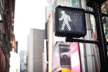 A crosswalk sign with the walk park lit up